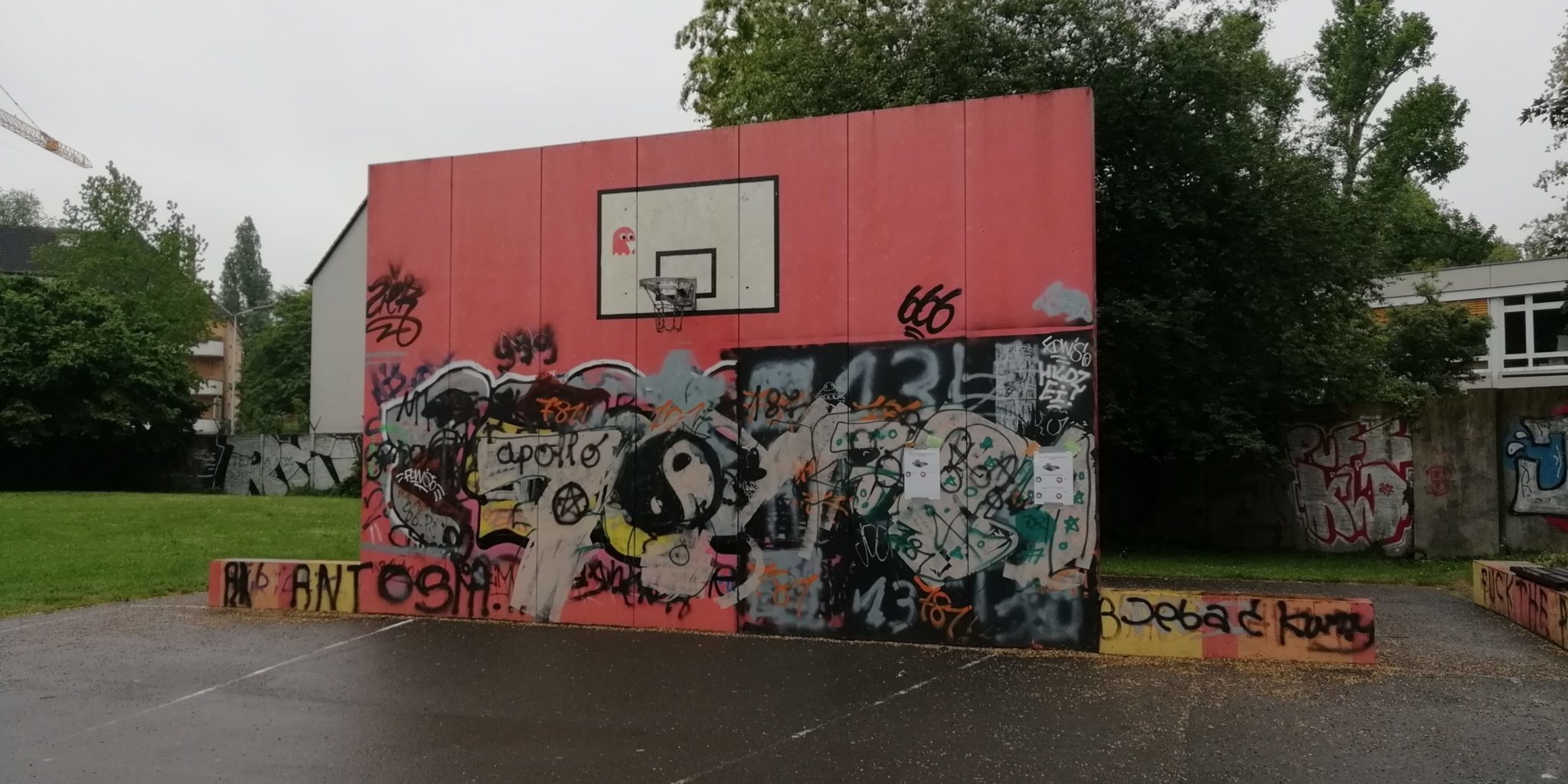 Basketballfeld mit vielen Graffitis an der Wand vom Korb