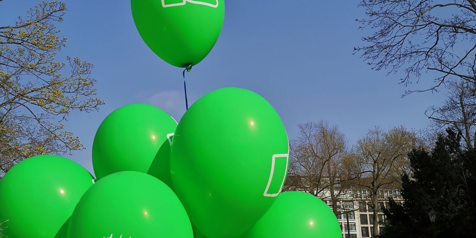 Grüne Luftballons mit Daumen hoch am Spielplatz Inselstraße im Hofgarten