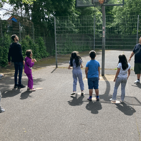 Kinder spielen Basketball auf der alten Fläche bei der Beteiligung