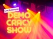 Bunte Scheinwerfer. Im Vordergrund steht: Live-Rollenspiel. Democracy Show.